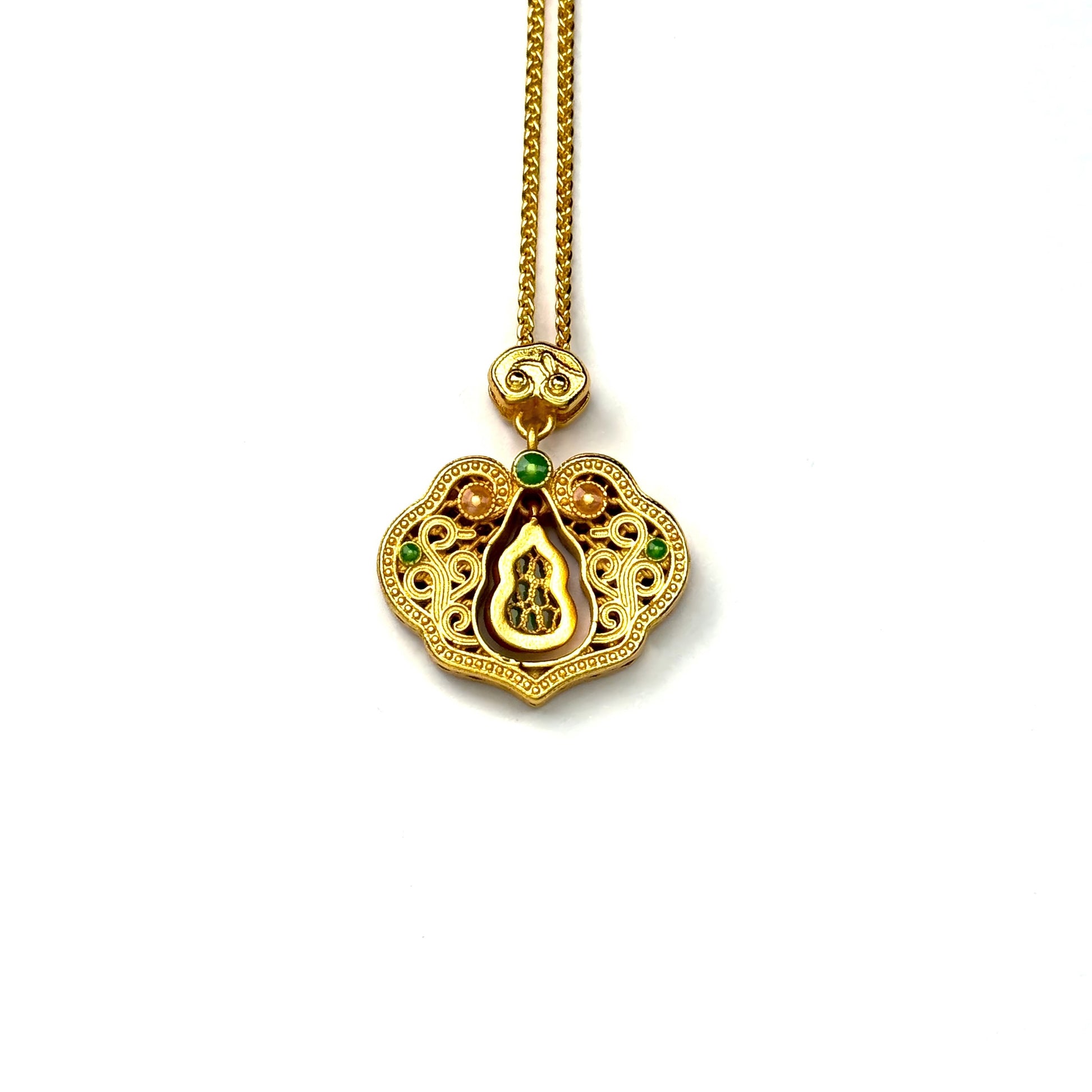 The back side of a sand gold longevity lock necklace, showcasing the finely brushed gold texture and the reverse view of the central green gemstone gourd.