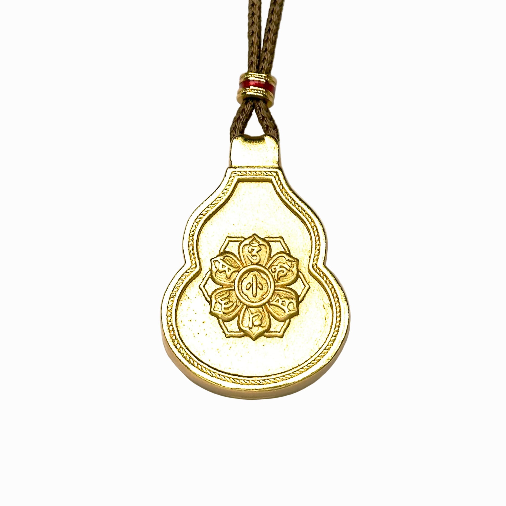 The reversible back side of a sand gold Hulu gourd pendant, showcasing an embossed six-syllable mantra lotus wheel motif on an antique matte gold background.