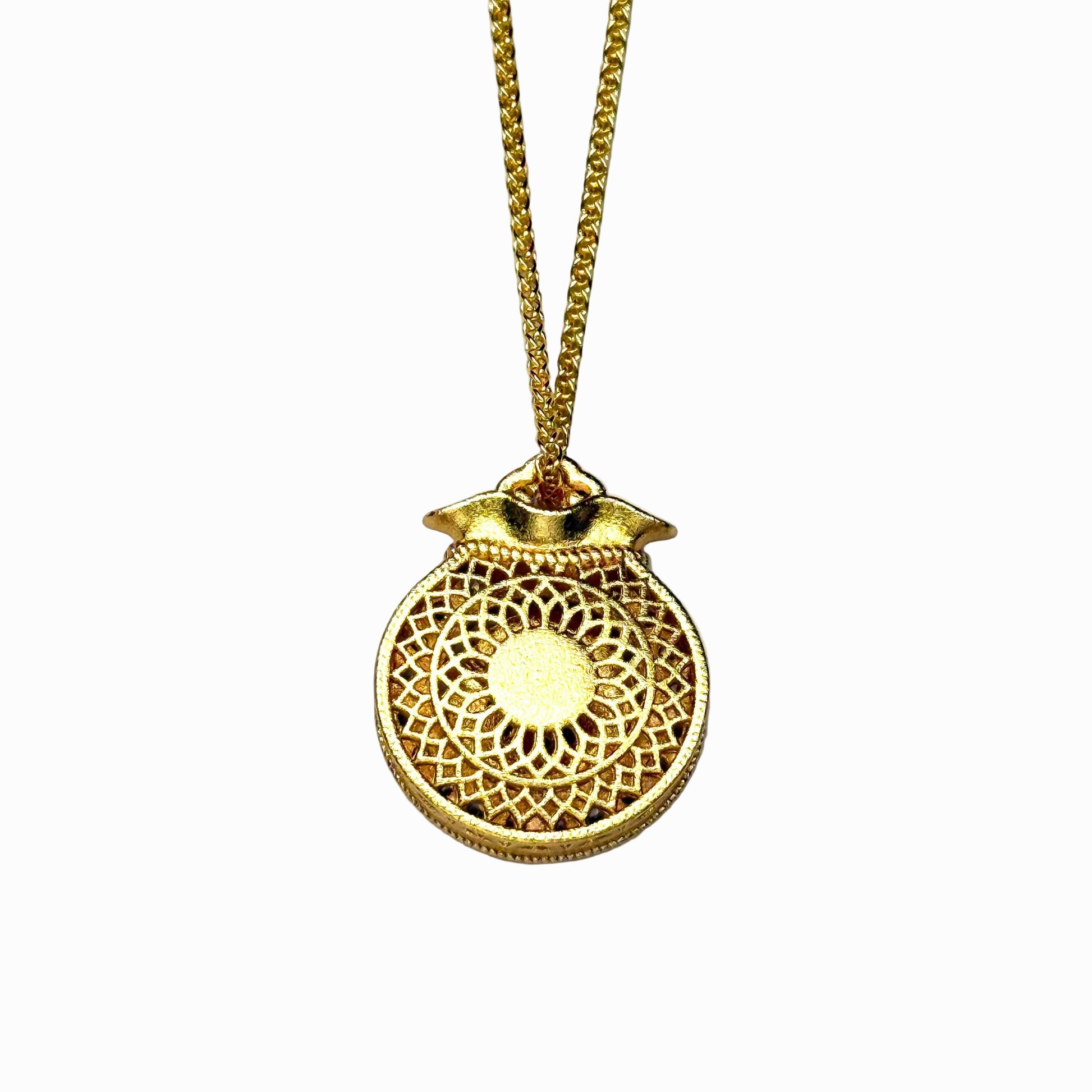 The reversible back side of a sand gold fortune pouch necklace, showcasing a minimalist, finely engraved sunburst geometric lattice openwork pattern on a white background.