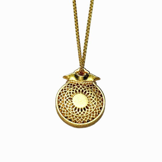 The reversible back side of a sand gold fortune pouch necklace, showcasing a minimalist, finely engraved sunburst geometric lattice openwork pattern on a white background.