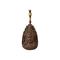 Front view of an agarwood Guanyin pendant with dark braided cord and red accent bead