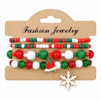 Bells & Snowflake — Christmas charm bracelet four-piece set, overhead view on white