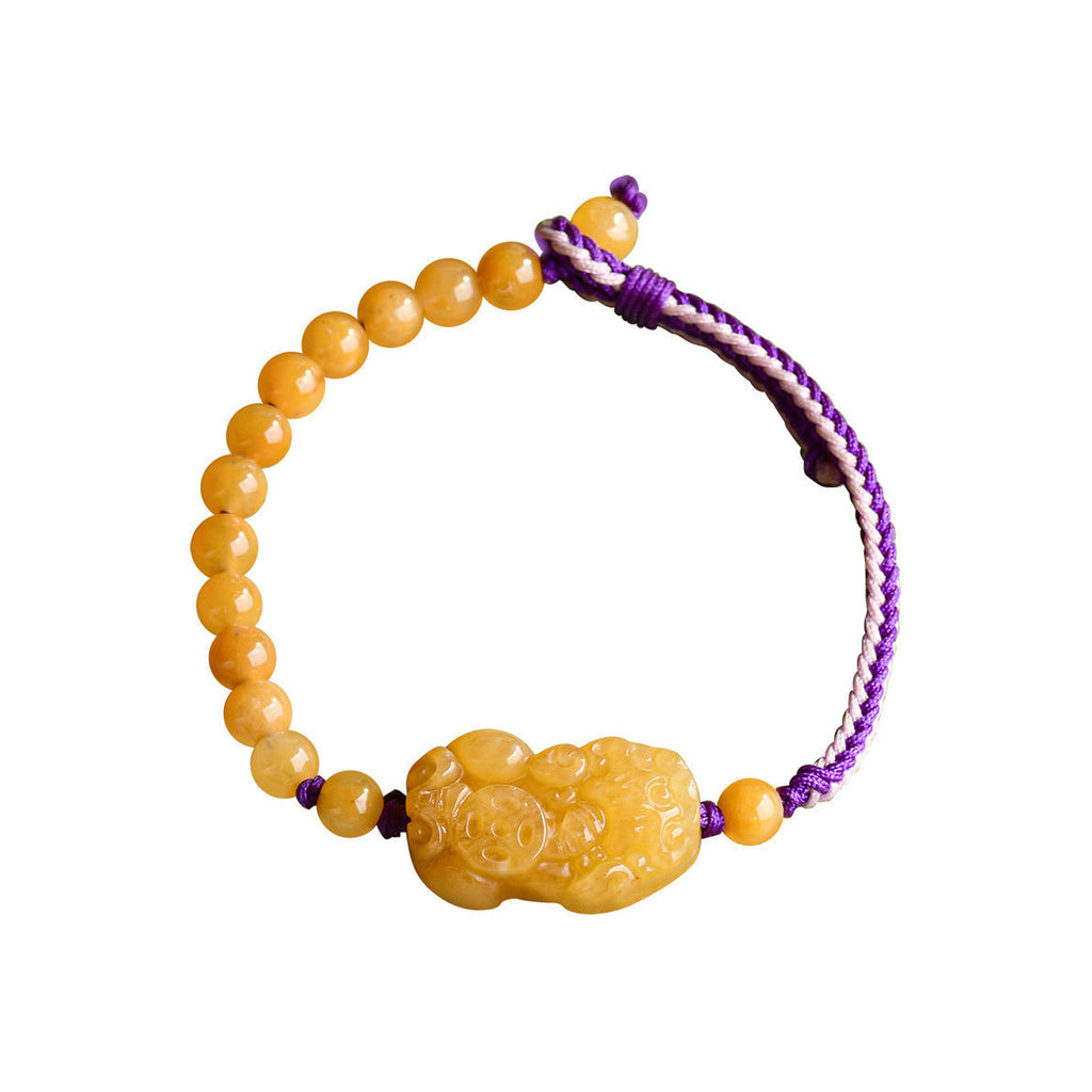 Golden Yellow Pixiu Cord Bracelet - overhead view on white