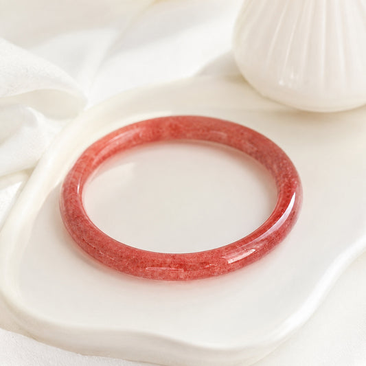 Strawberry quartz bangle bracelet displayed on a white jewelry tray