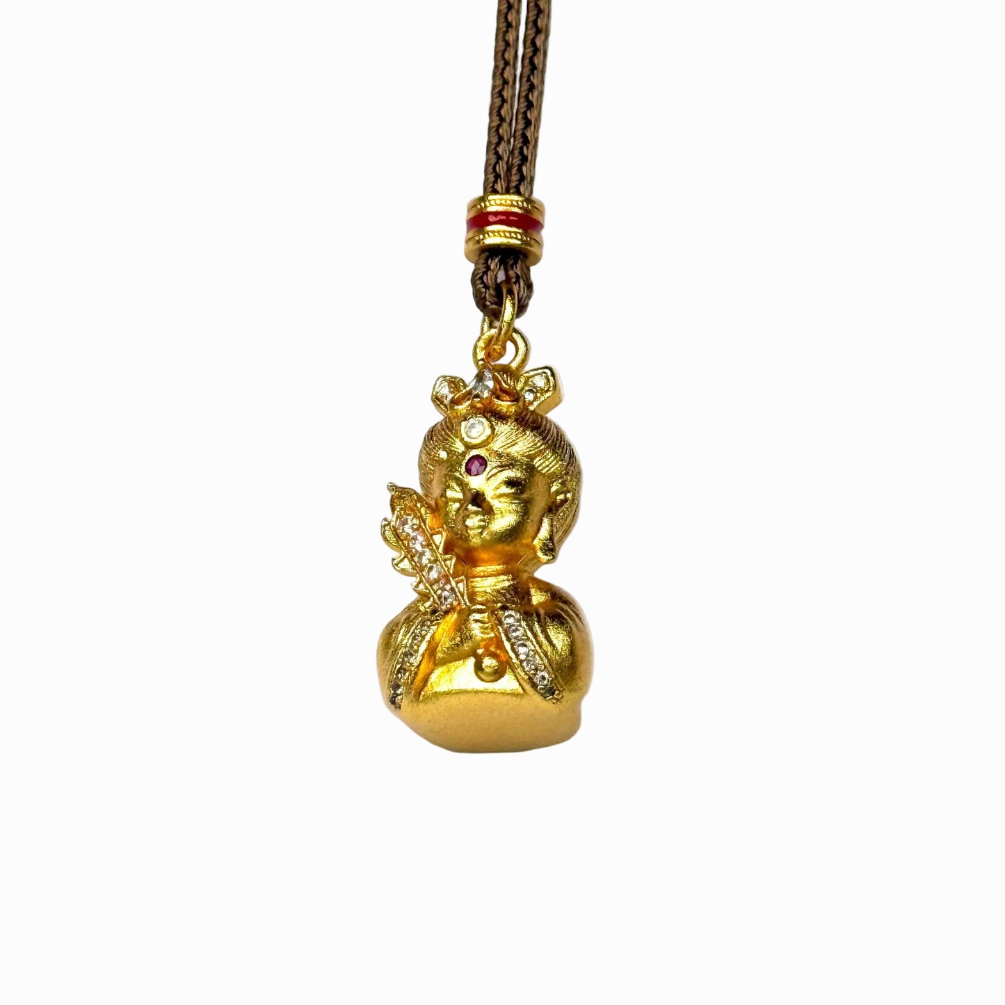 An angled side-front view of an embossed sand gold oriental Buddha deity charm, highlighting its three-dimensional sculpting and diamond scepter accents.