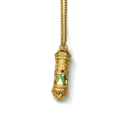 The alternative view of a rotating gold Tibetan prayer cylinder necklace, showcasing its smooth spinning mechanism and colorful enamel inlay against a white background.