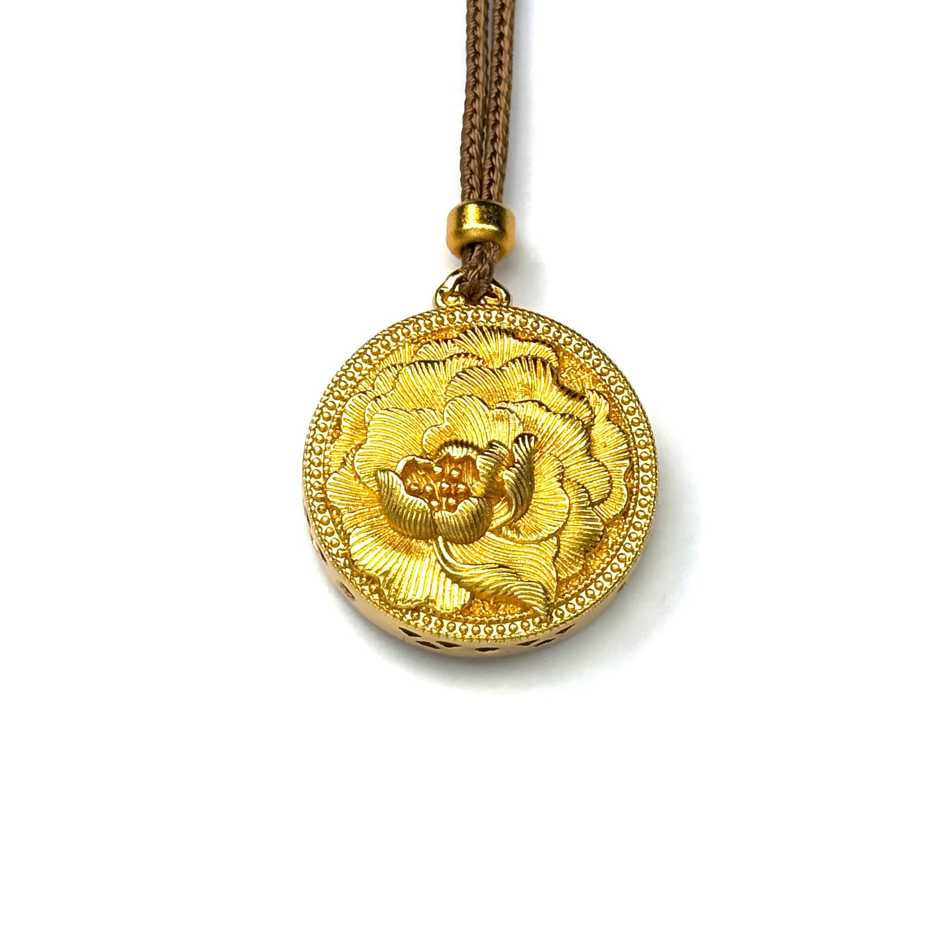 A front view of a pure sand gold round pendant featuring a stunning 3D embossed blooming peony flower on a white background.
