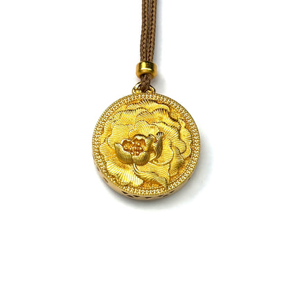A front view of a pure sand gold round pendant featuring a stunning 3D embossed blooming peony flower on a white background.