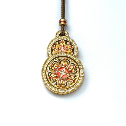 A front view of an authentic sand gold Hulu gourd shape pendant featuring rich orange enamel lotus mandala and a brilliant double-row rhinestone border on a white background.
