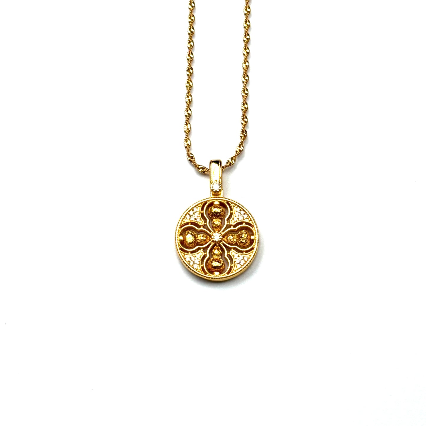 A front view of an authentic sand gold crossed Vajra pendant featuring a brilliant crystal rhinestone pavé background on a gold chain, displayed against a white background.