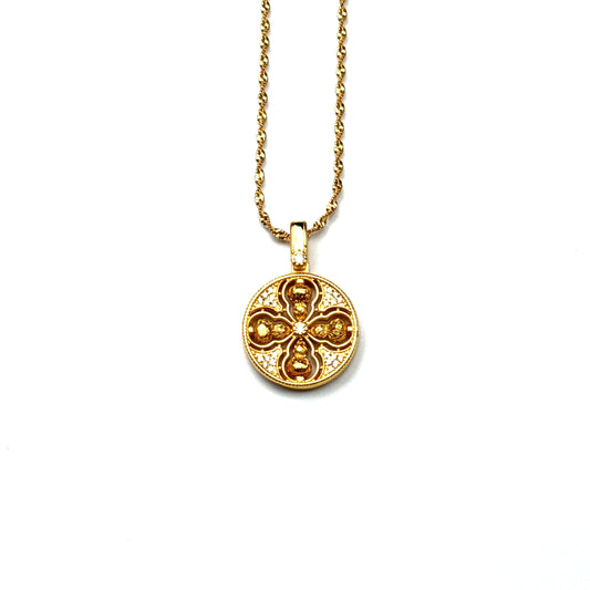 A front view of an authentic sand gold crossed Vajra pendant featuring a brilliant crystal rhinestone pavé background on a gold chain, displayed against a white background.