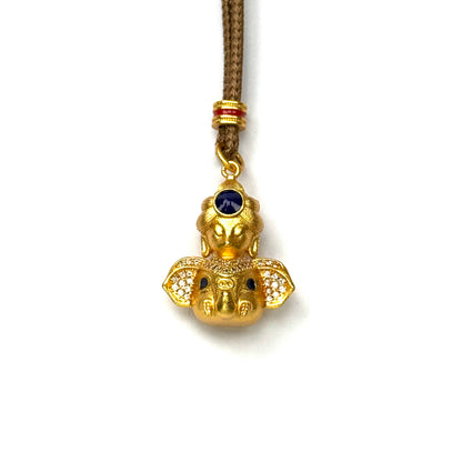 A front view of an authentic sand gold Lord Ganesha elephant pendant featuring rhinestone ears and a blue gemstone crown on a white background.