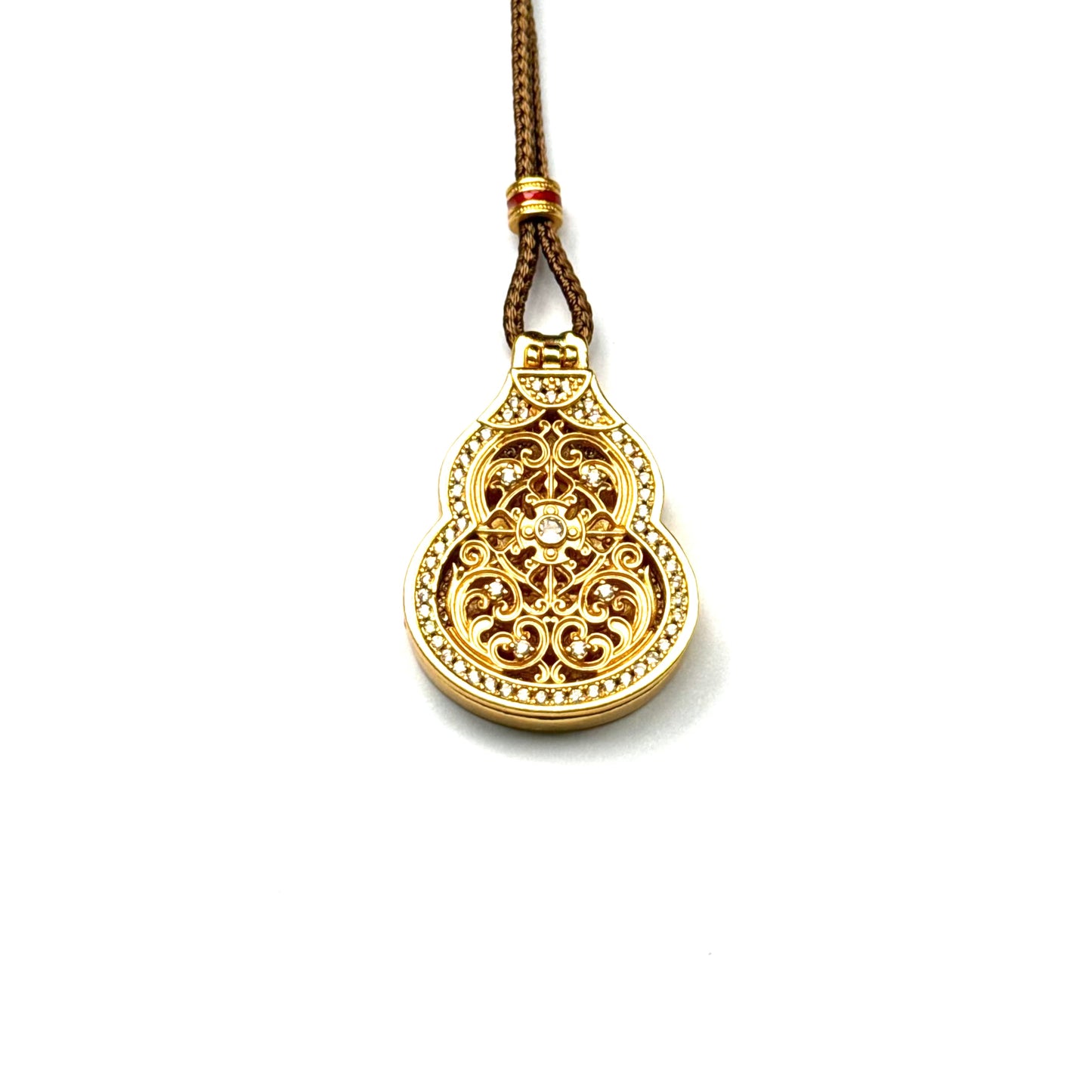 A front view of a closed sand gold Hulu gourd locket pendant featuring detailed openwork filigree and a sparkling rhinestone border on a white background.
