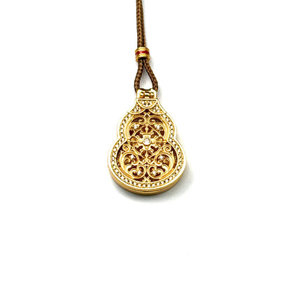 A front view of a closed sand gold Hulu gourd locket pendant featuring detailed openwork filigree and a sparkling rhinestone border on a white background.