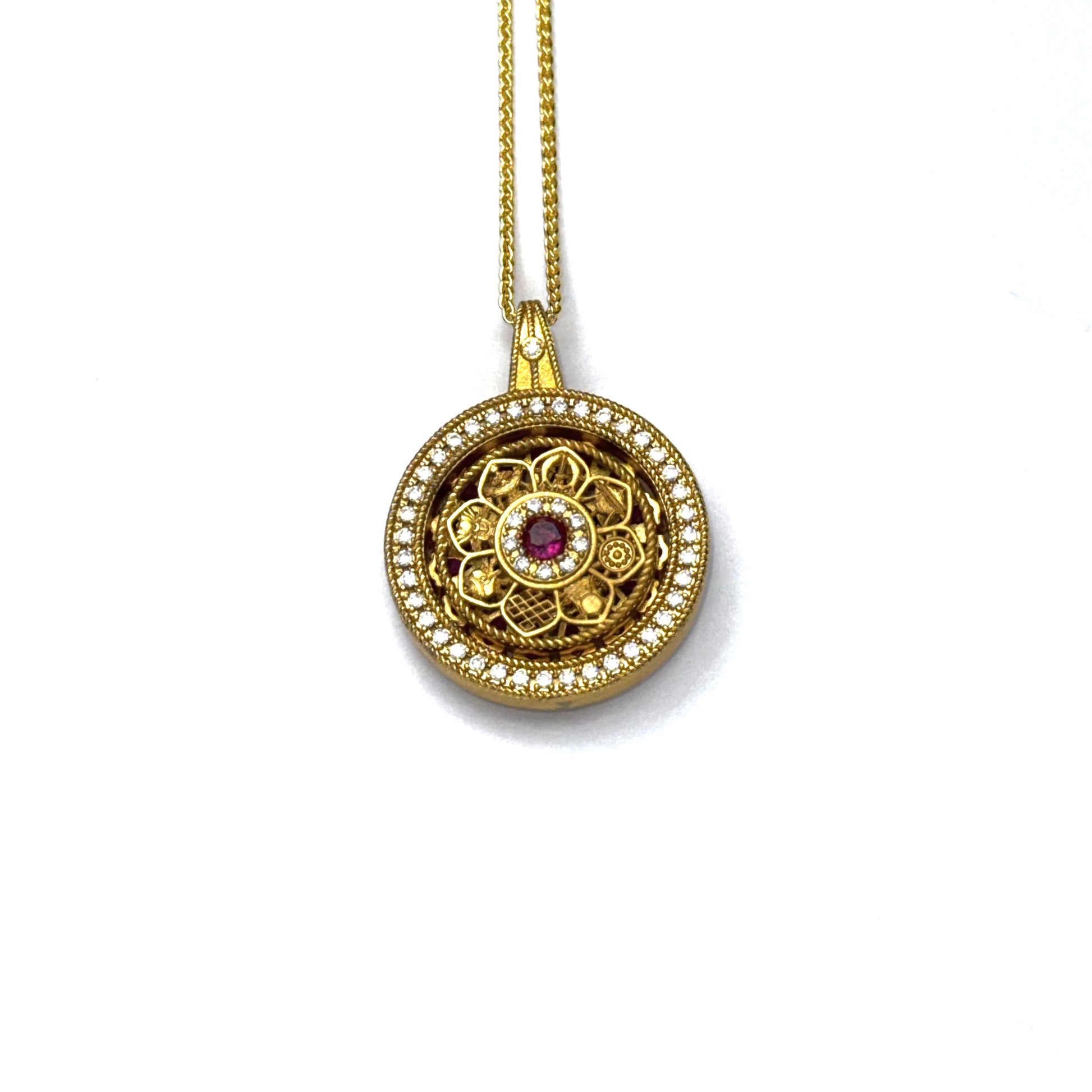 The detailed back view of a sand gold rotating wheel pendant, showcasing an intricate openwork filigree pattern on a white background.