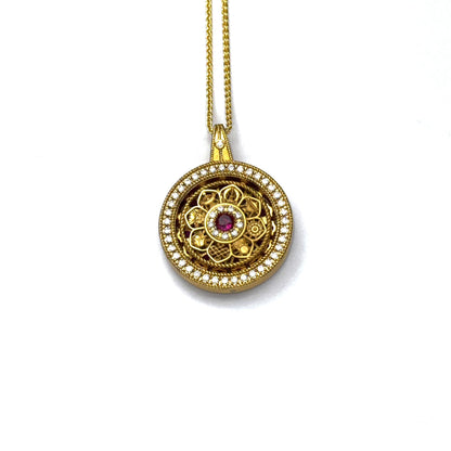 The detailed back view of a sand gold rotating wheel pendant, showcasing an intricate openwork filigree pattern on a white background.