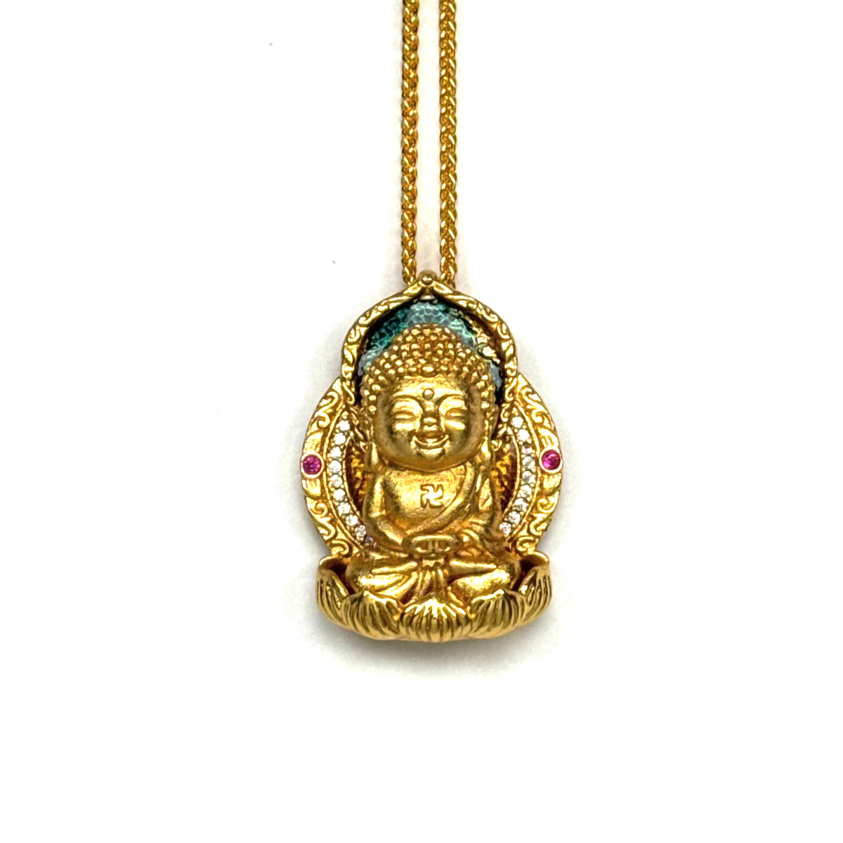 A front-view close-up of an authentic sand gold seated Buddha pendant, featuring a Swastika symbol, blue enamel halo, and pink accent stones on a gold chain against a white background.