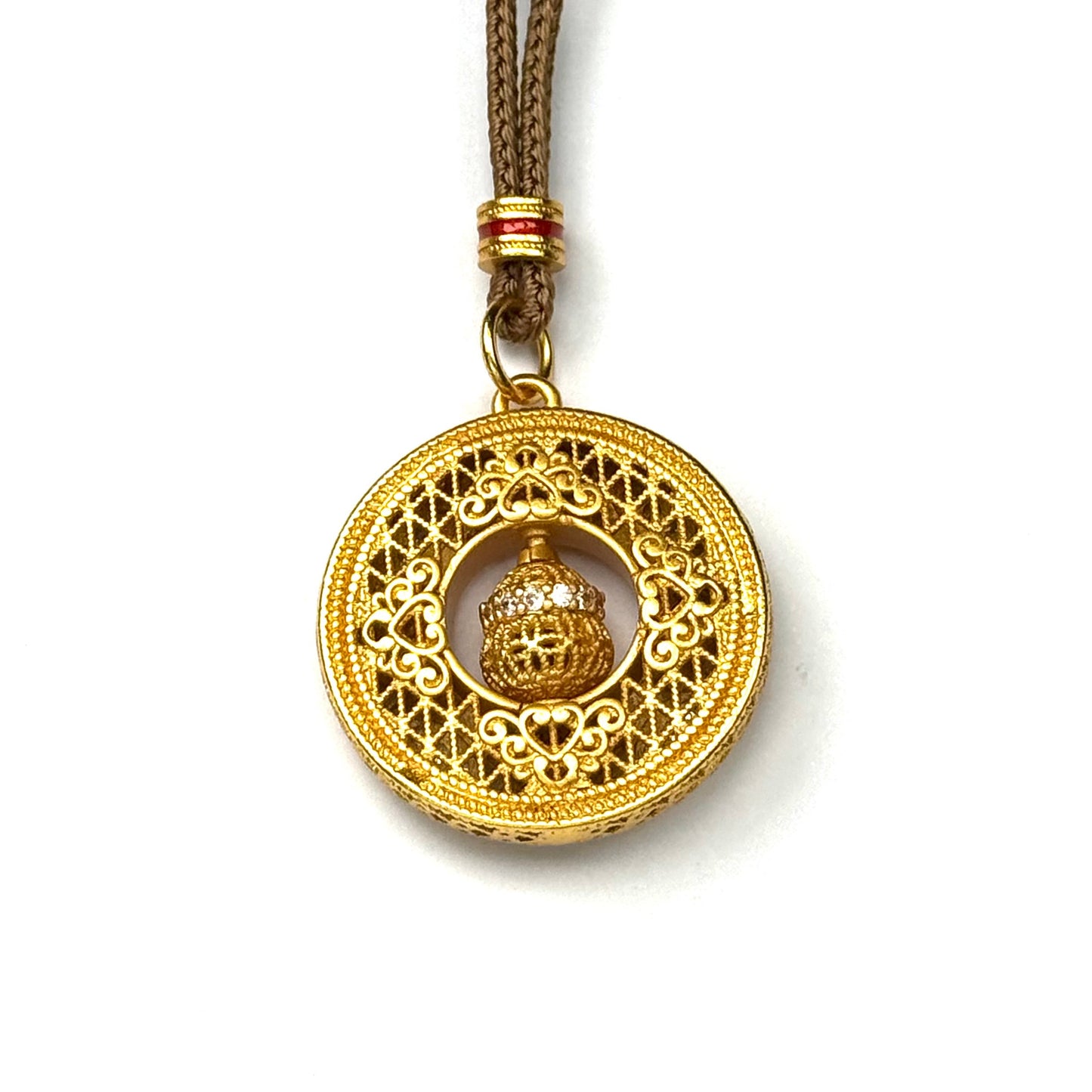 The reversible back side of a sand gold round amulet necklace, showcasing a minimalist, finely engraved geometric lattice openwork pattern on a white background.