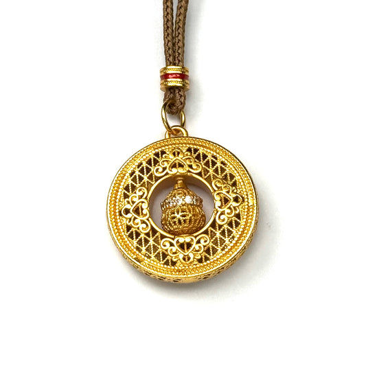The reversible back side of a sand gold round amulet necklace, showcasing a minimalist, finely engraved geometric lattice openwork pattern on a white background.