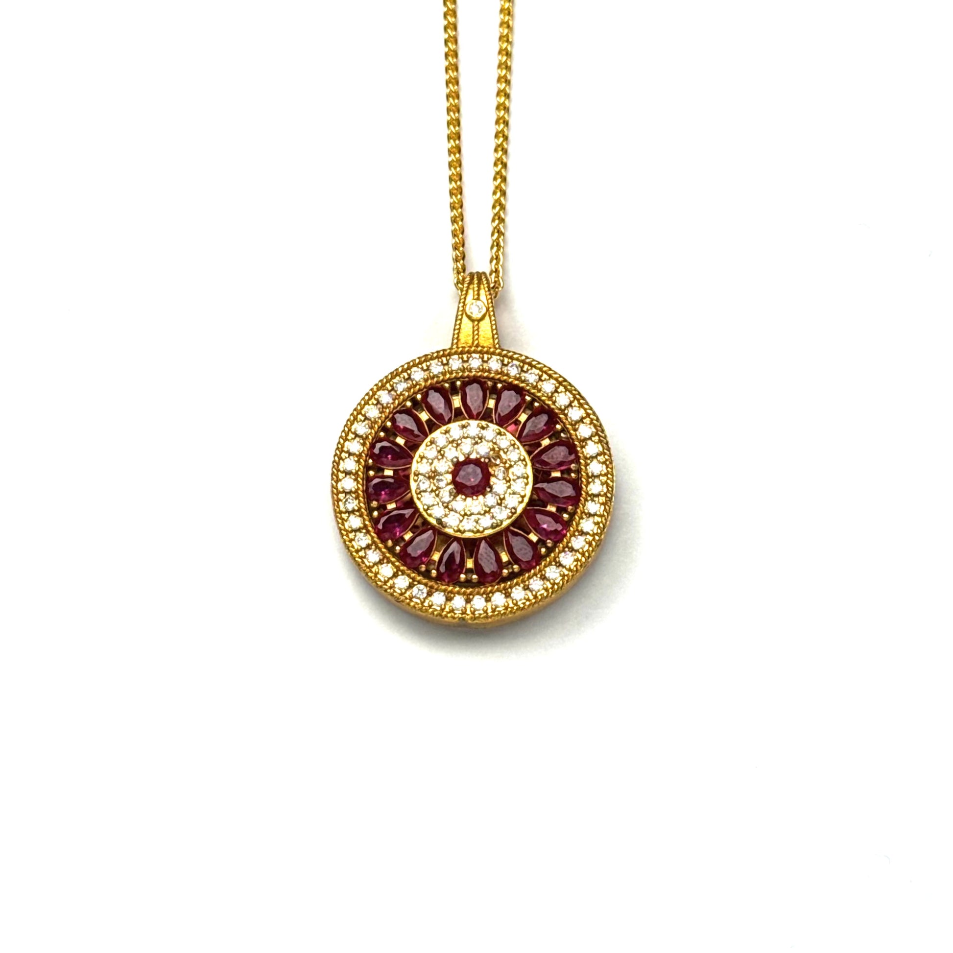 A front view of an authentic sand gold spinning Dharma wheel pendant with colorful enamel accents and a rhinestone border on a white background.