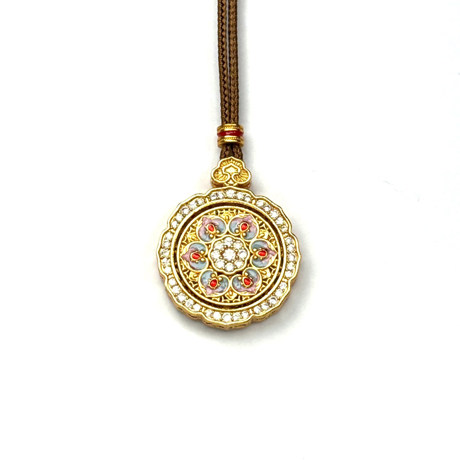 A front view of a sand gold spinning lotus pendant featuring pastel pink and blue enamel detailing with a sparkling rhinestone border on a white background.