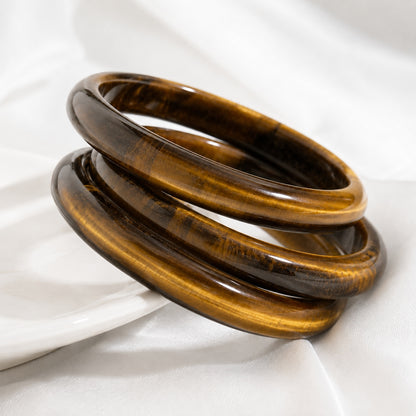 Stacked tiger’s eye bangle bracelets with natural golden chatoyancy