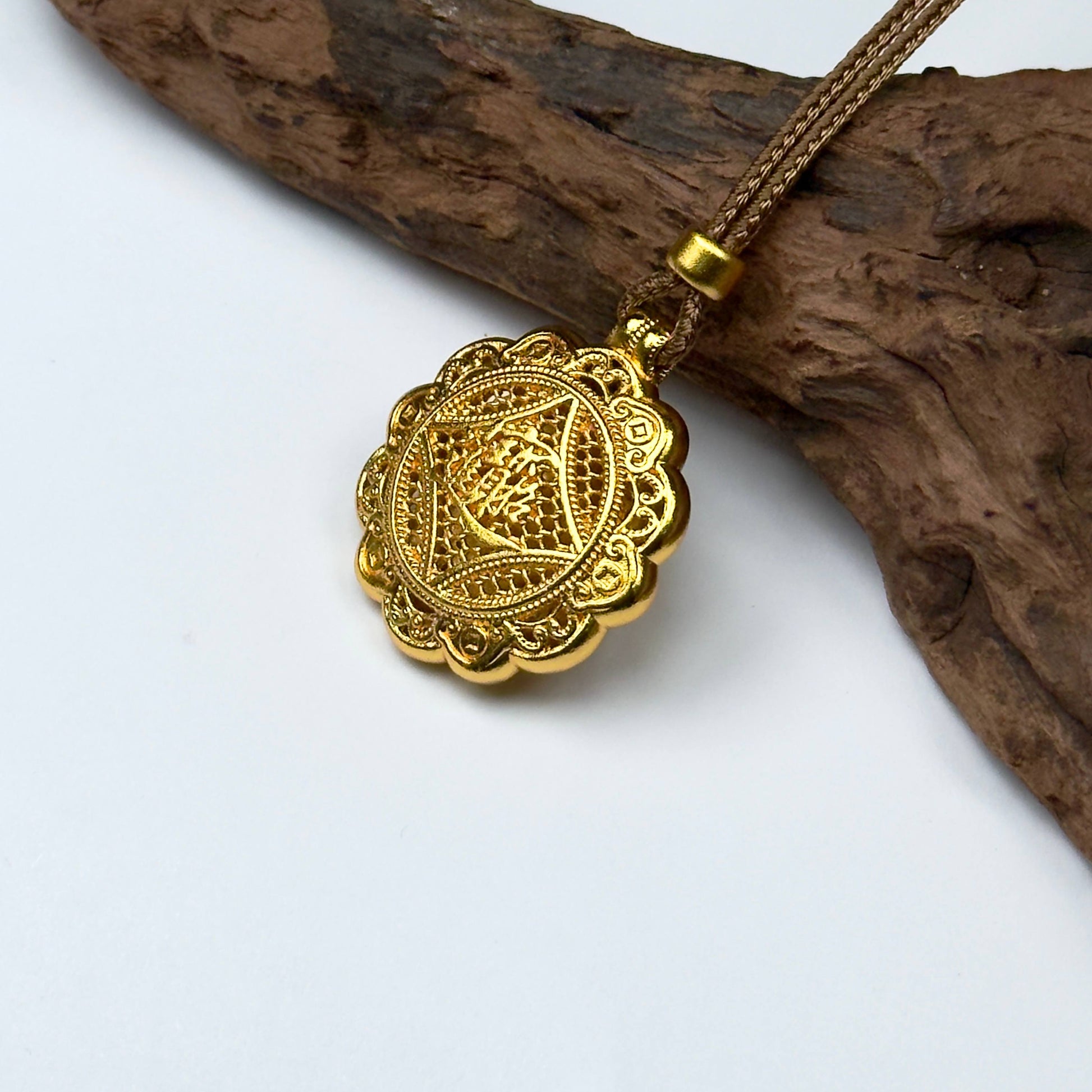A luxurious sand gold kinetic Pixiu fortune wheel pendant with shimmering crystal rhinestones, displayed mid-spin against a natural rustic driftwood branch.