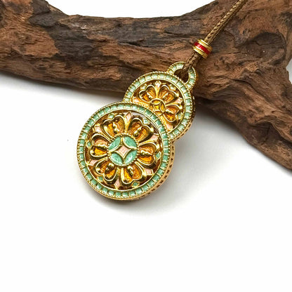 A luxurious sand gold orange enamel lotus Hulu gourd talisman displayed beautifully against a natural rustic driftwood branch for a Zen look.