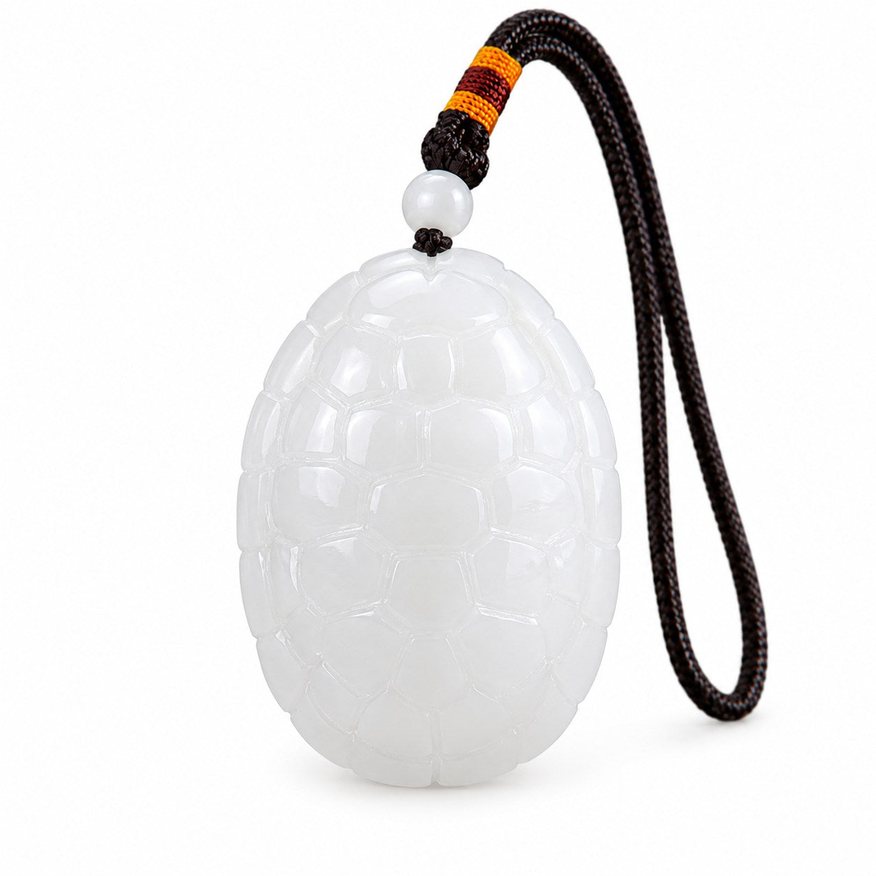 Front view of a white jade turtle amulet pendant with carved shell pattern and dark braided cord