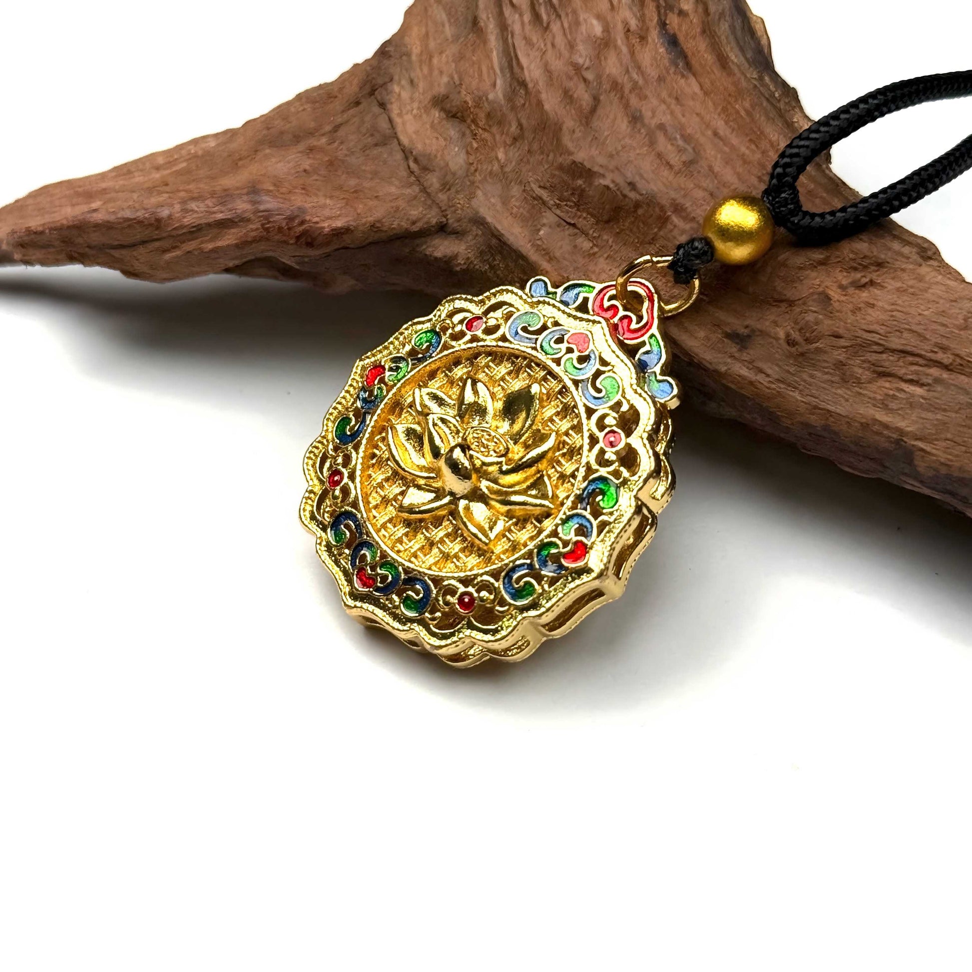 The beautiful reversible "Fu" fortune side of a colorful sand gold enamel amulet displayed beautifully against a natural rustic wood background.