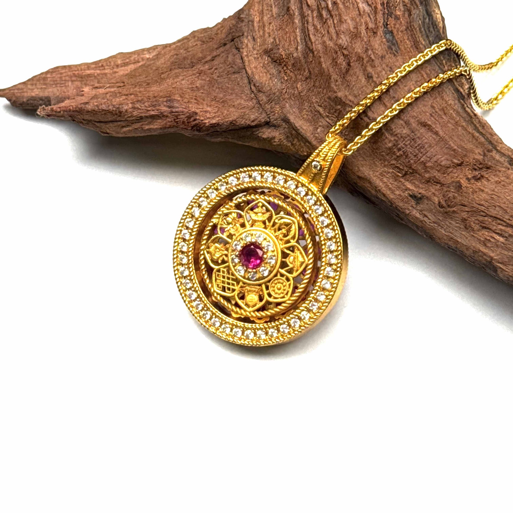 A luxurious sand gold Dharma wheel talisman with rich enamel inlay resting on rustic driftwood for a serene Zen aesthetic.