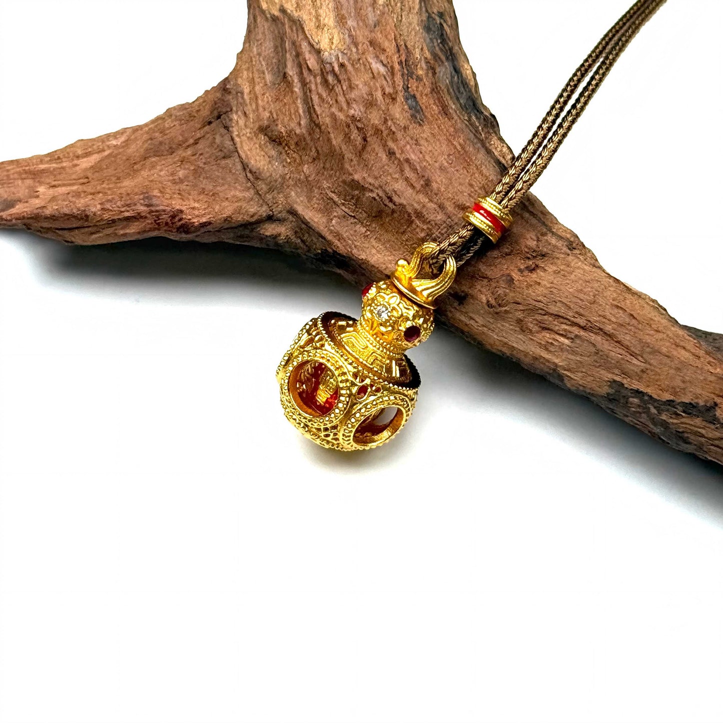 A luxurious sand gold Hulu abundance gourd pendant with a 3D hollow orb structure resting elegantly on natural rustic wood for a Zen look.