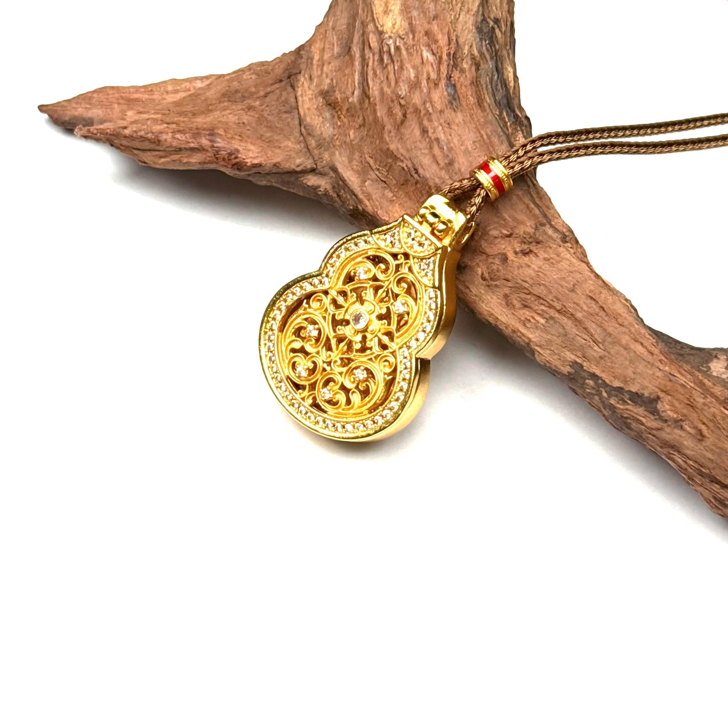 An opened golden Buddha locket amulet inside a sand gold Hulu gourd shape, displayed beautifully on a piece of natural wood.