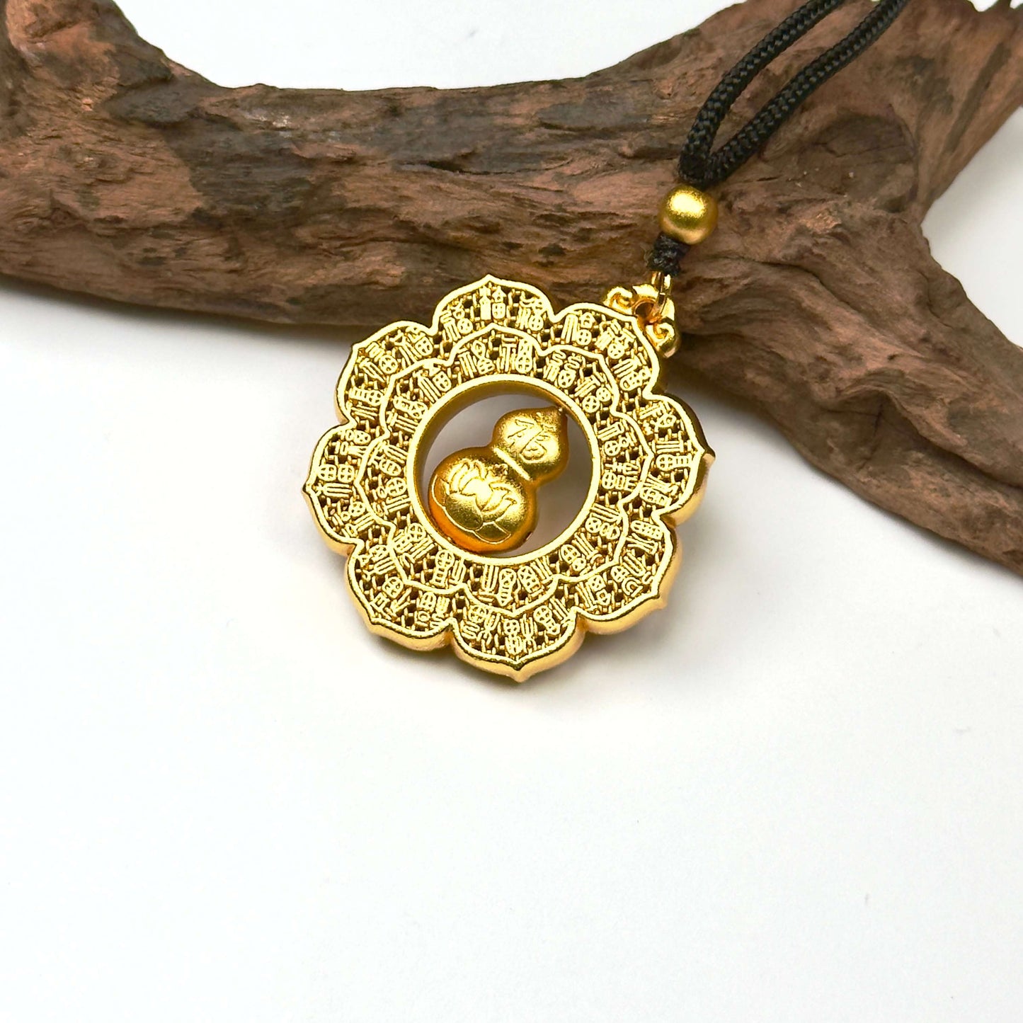 A regal sand gold kinetic fortune wheel amulet with a 3D rotating gourd center, displayed elegantly against a rustic driftwood branch for a Zen look.