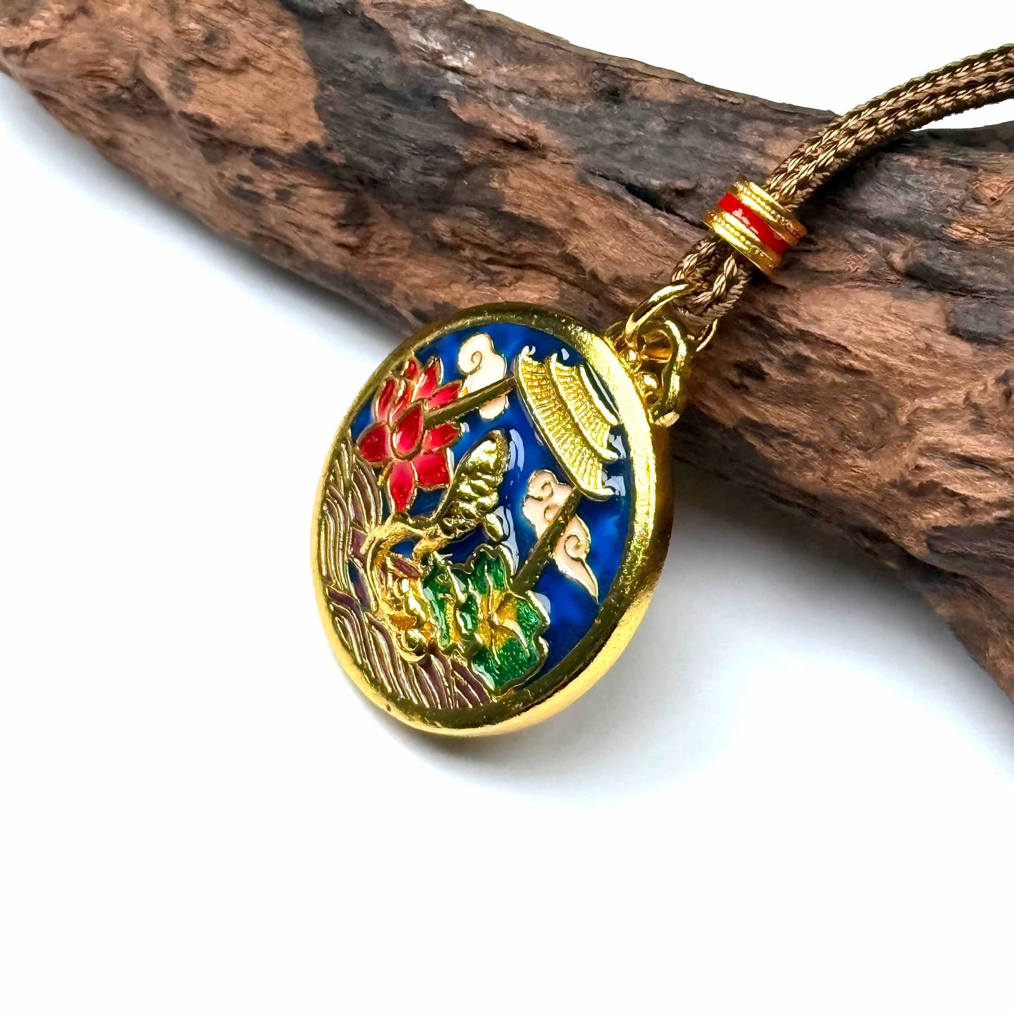 A luxurious sand gold and colorful enamel koi fish breakthrough amulet resting gracefully on rustic wood for a beautiful Zen look.