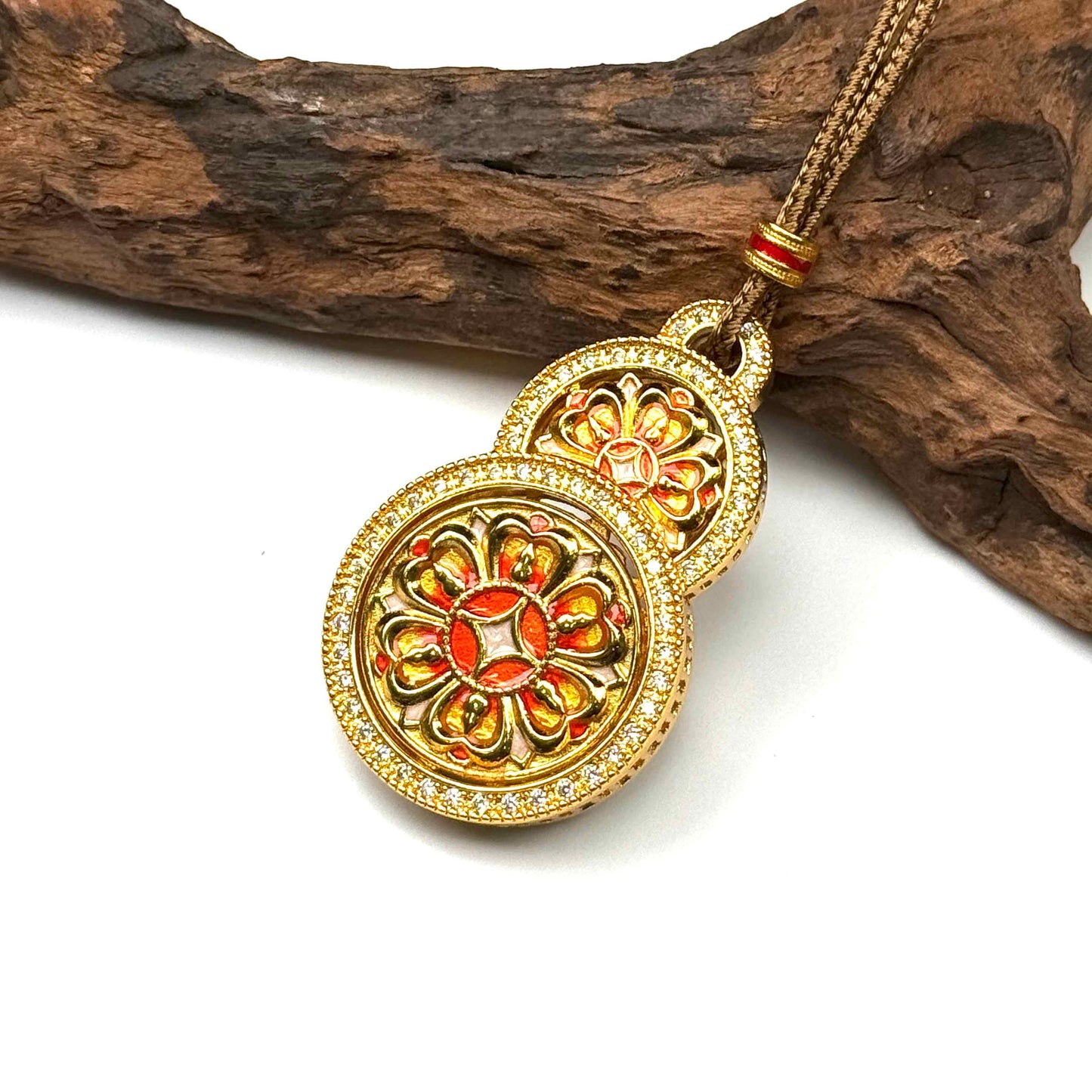 Angled view of a beautiful mint green enamel sand gold Hulu gourd amulet resting gracefully on rustic wood background.