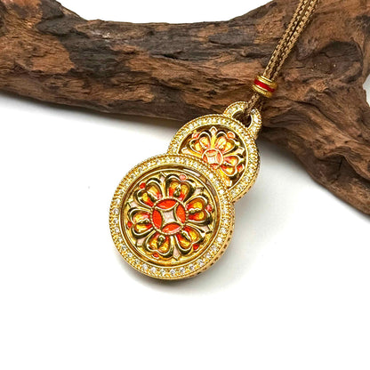 Angled view of a beautiful mint green enamel sand gold Hulu gourd amulet resting gracefully on rustic wood background.
