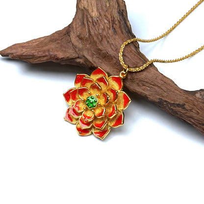 A luxurious sand gold and red enamel layered lotus rebirth amulet resting elegantly on a rustic driftwood branch for a dramatic Zen look.